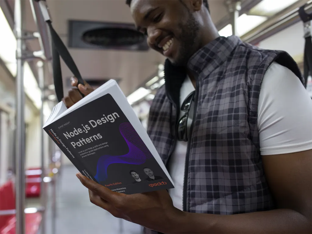 Man reading 'Node.js Design Patterns – Fourth Edition' on a subway train, standing and smiling; front cover with the purple wave design visible.